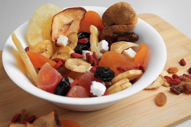 Photo of Bowl with different dried fruits on white background, closeup