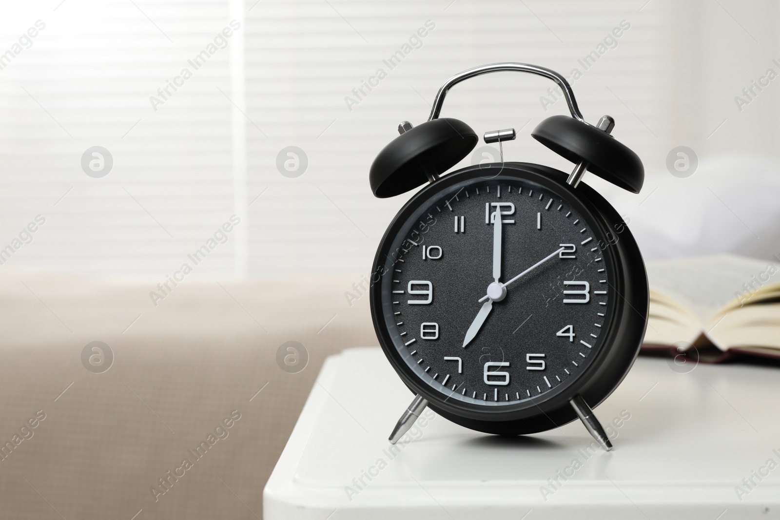 Photo of Black alarm clock on white wooden nightstand in bedroom, space for text