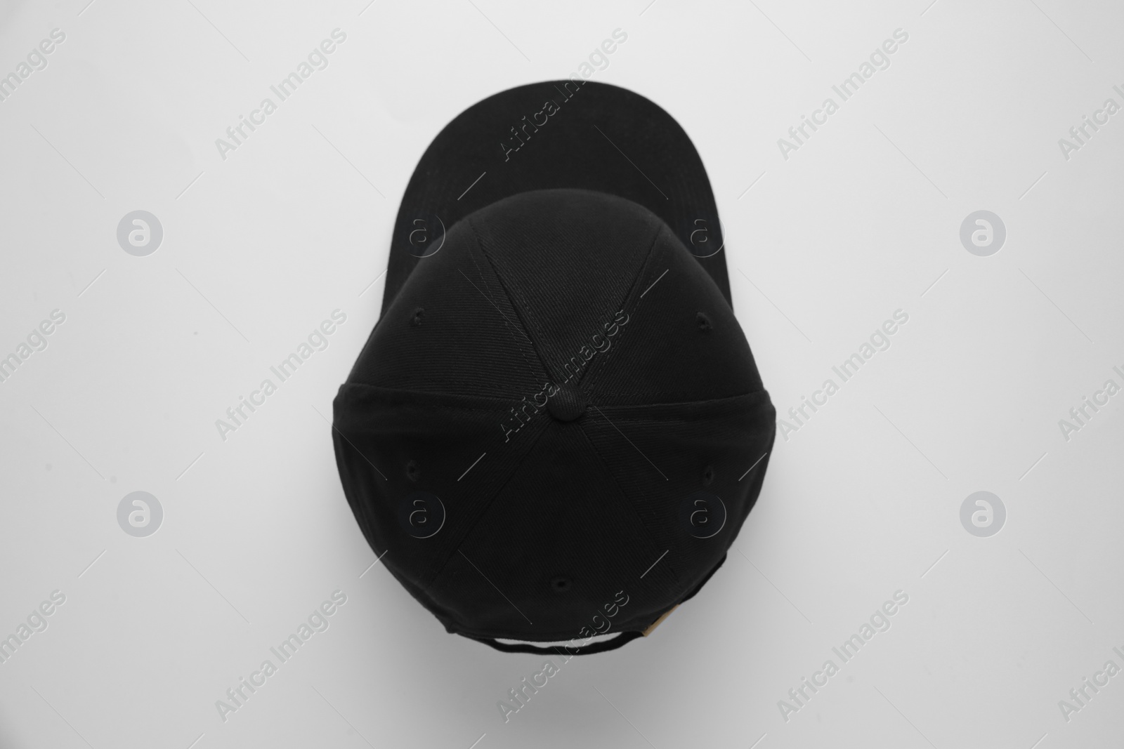 Photo of Stylish black baseball cap on white background, top view