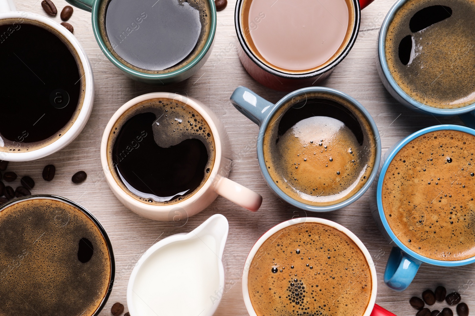 Photo of Many different cups of coffee and milk on white wooden table, flat lay