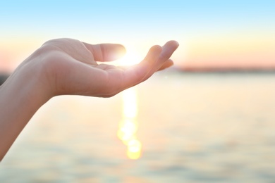 Woman enjoying beautiful sunset outdoors, closeup view