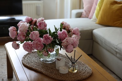 Beautiful pink peonies in vase on table at home, space for text. Interior design