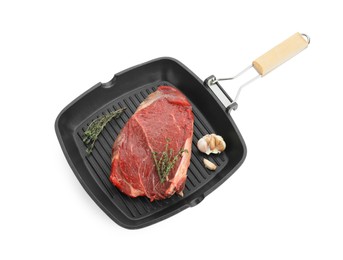 Photo of Grill pan with piece of raw beef meat, garlic and thyme isolated on white
