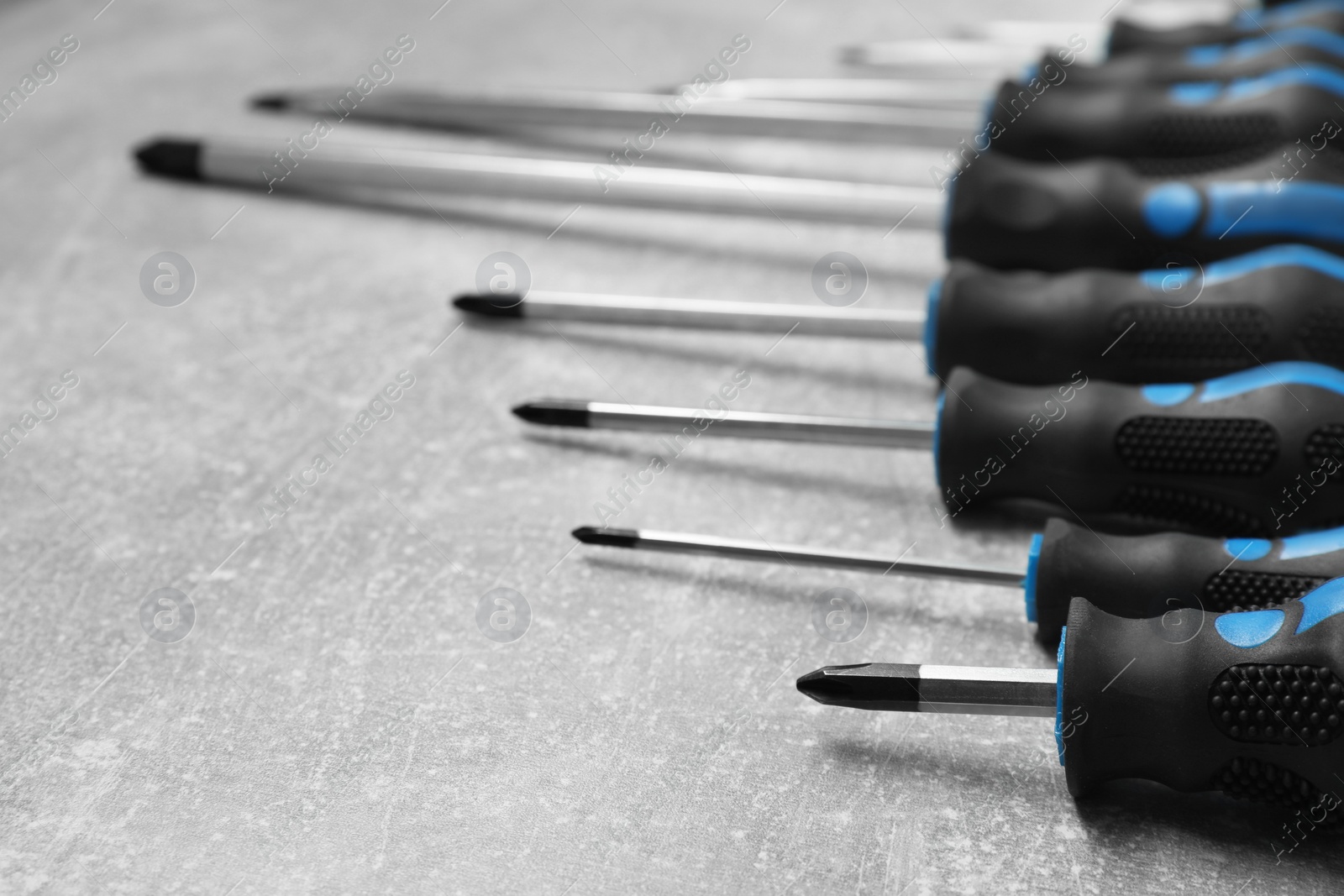 Photo of Set of screwdrivers on grey table, closeup