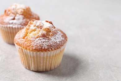 Delicious sweet muffins on light grey textured table, closeup. Space for text