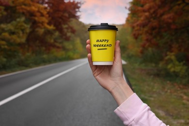 Image of Happy Weekend. Woman with takeaway coffee cup near road outdoors, closeup