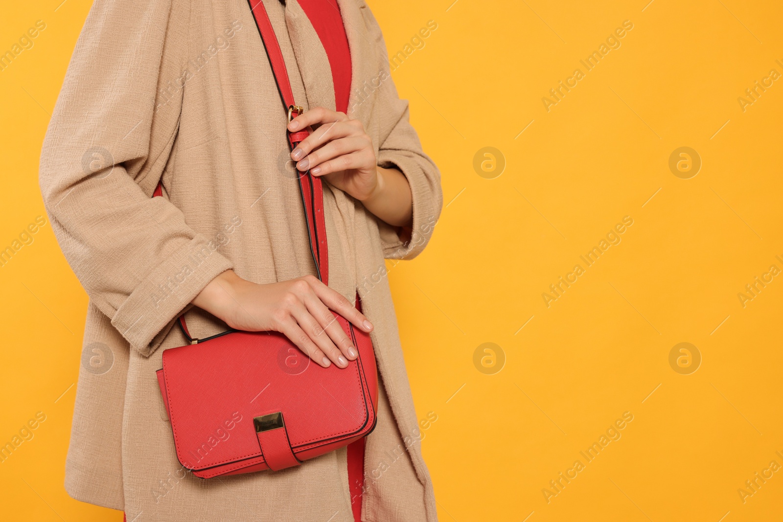 Photo of Woman with stylish bag on yellow background, closeup. Space for text