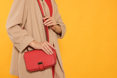 Woman with stylish bag on yellow background, closeup. Space for text