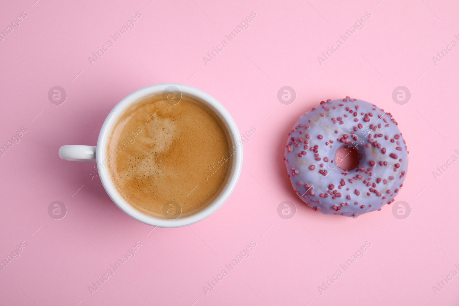 Photo of Delicious coffee and donut on light pink background, flat lay. Sweet pastries