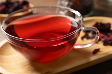 Cup of fresh hibiscus tea on table, closeup