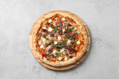 Tasty pizza with anchovies, arugula and olives on grey table, top view