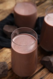 Photo of Delicious chocolate milk in glasses on wooden table