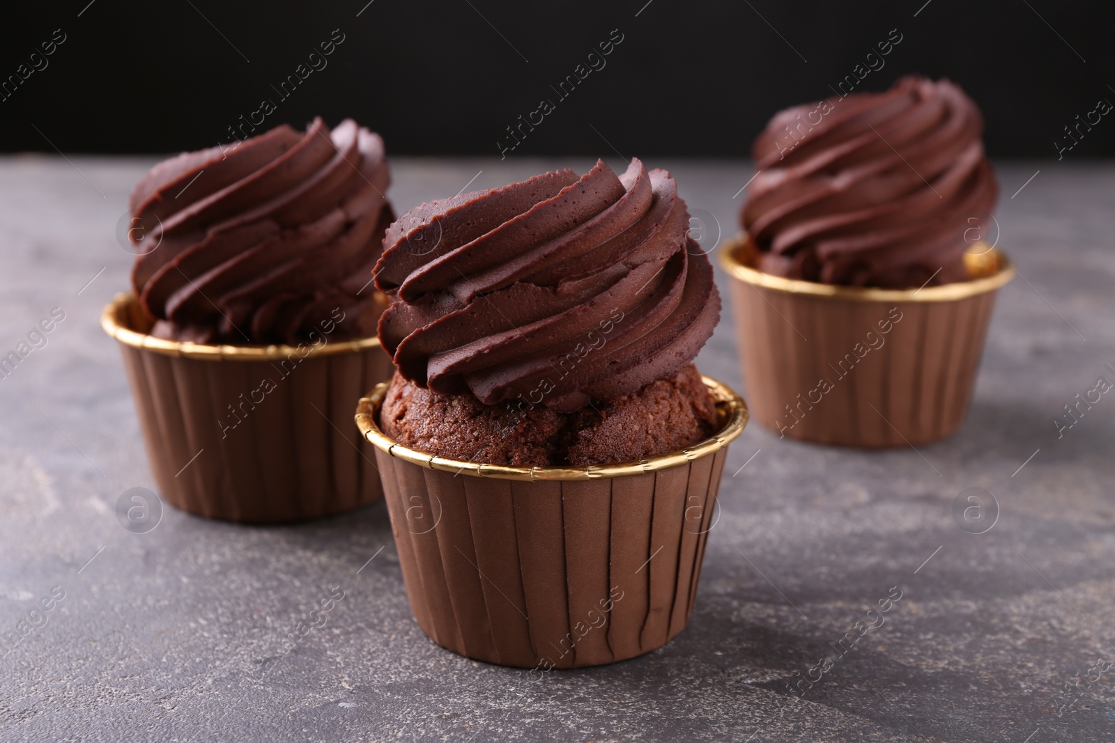 Photo of Delicious chocolate cupcakes on grey table, closeup