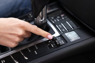 Woman using gear stick while driving her car, closeup