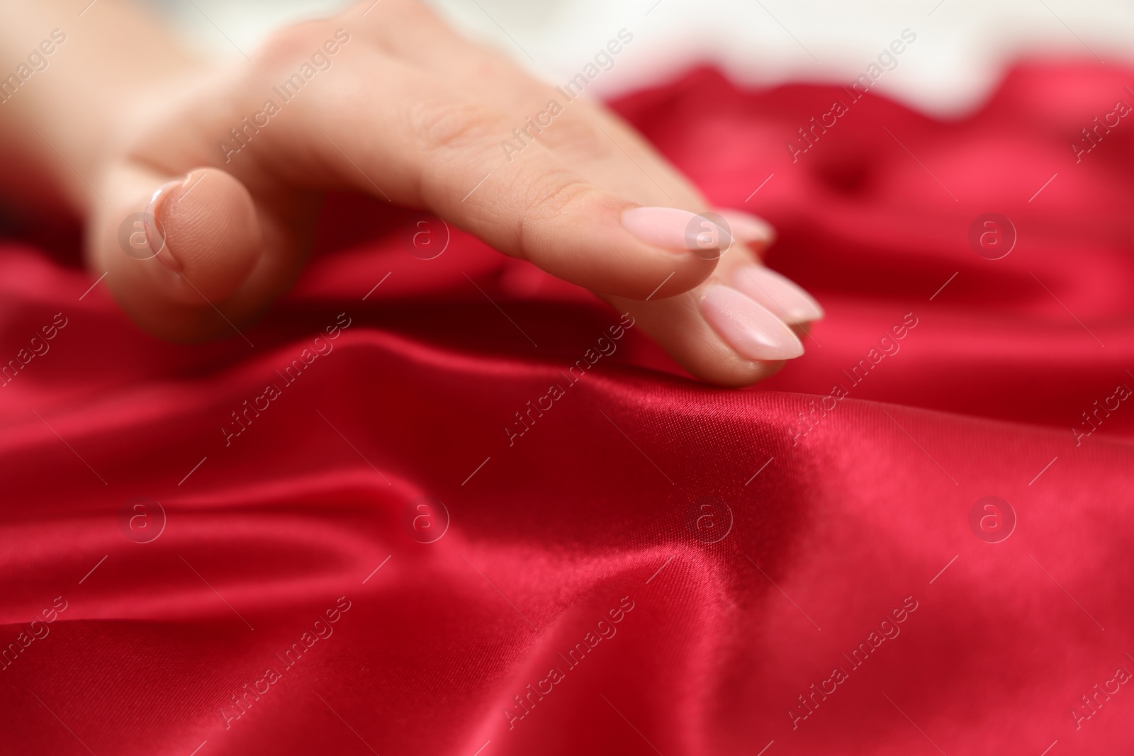 Photo of Woman touching smooth silky fabric, closeup view