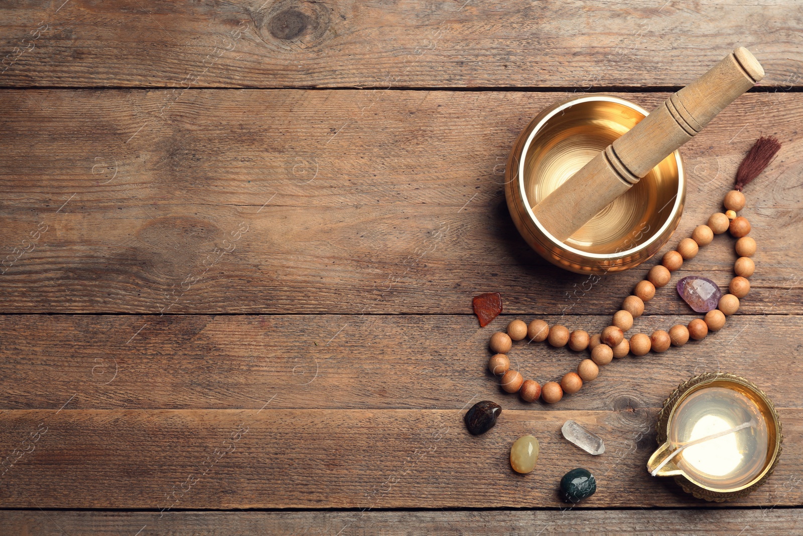 Photo of Flat lay composition with golden singing bowl on wooden table, space for text. Sound healing