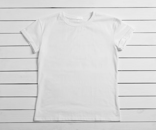 Photo of Stylish t-shirt on white wooden background, top view