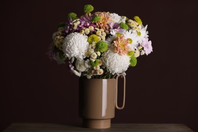 Photo of Bouquet of beautiful chrysanthemum flowers on table against dark background