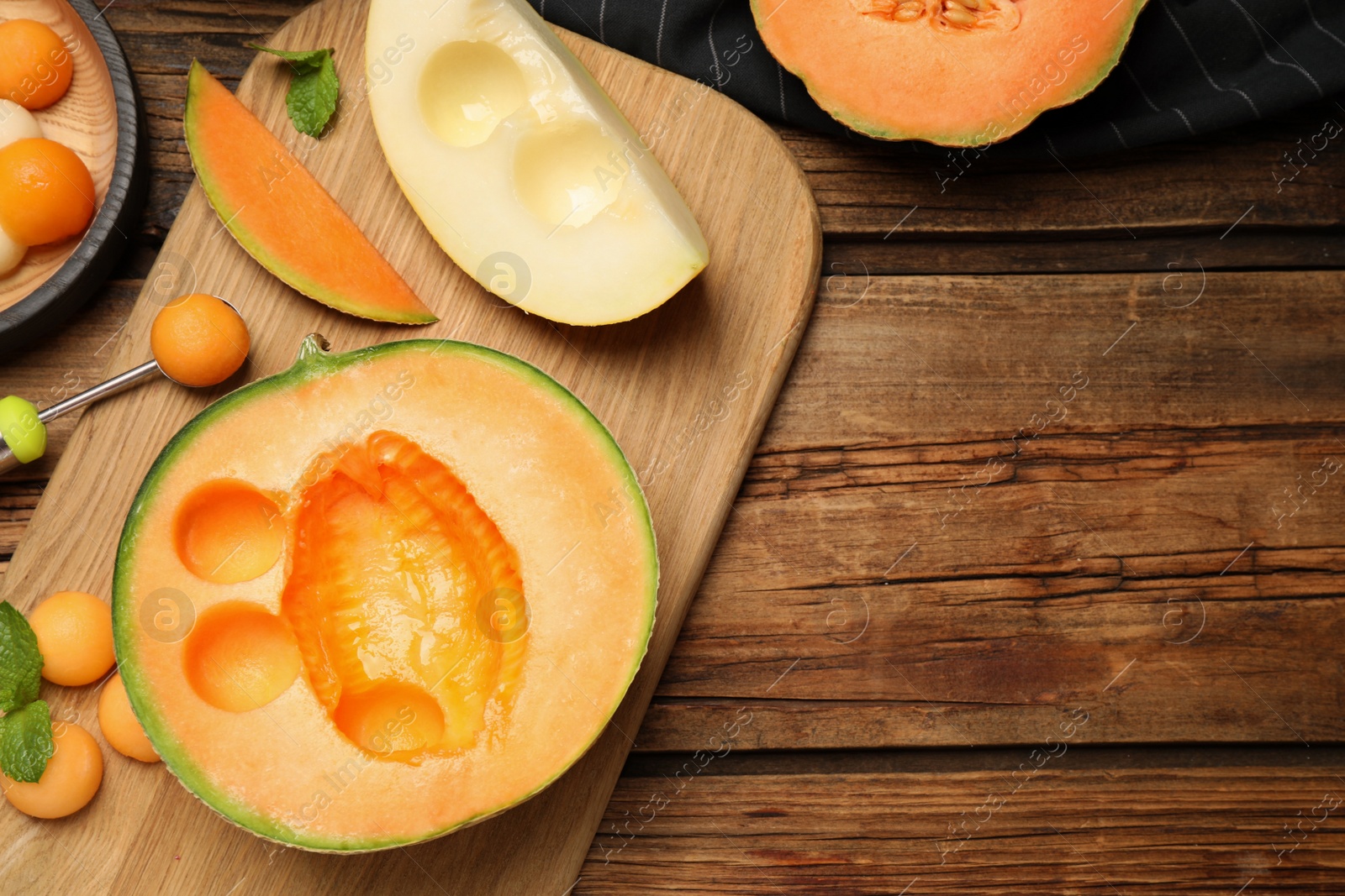 Photo of Flat lay composition with melon balls on wooden table, space for text