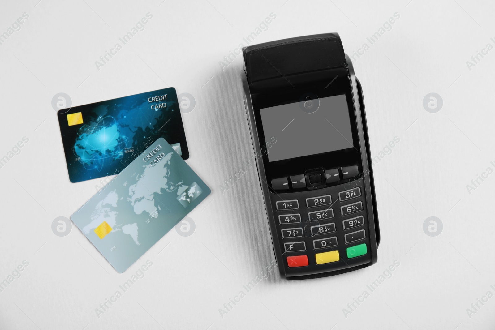 Photo of Modern payment terminal and credit cards on grey background, top view