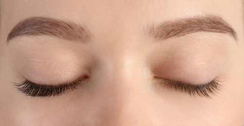 Young woman with beautiful eyelashes, closeup. Before and after extension procedure