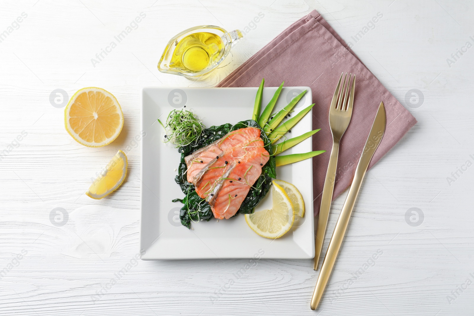 Photo of Tasty salmon with spinach served on white wooden table, flat lay