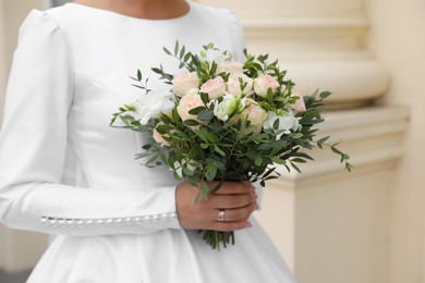 Photo of Bride wearing engagement ring and wedding dress with beautiful bouquet outdoors, closeup
