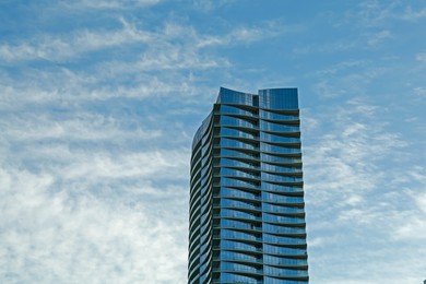 Photo of Exterior of modern skyscraper against blue sky, space for text