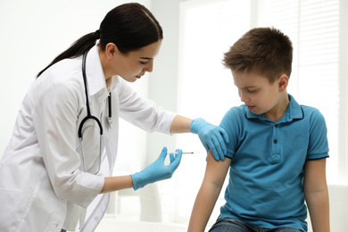 Photo of Doctor vaccinating little child in modern clinic