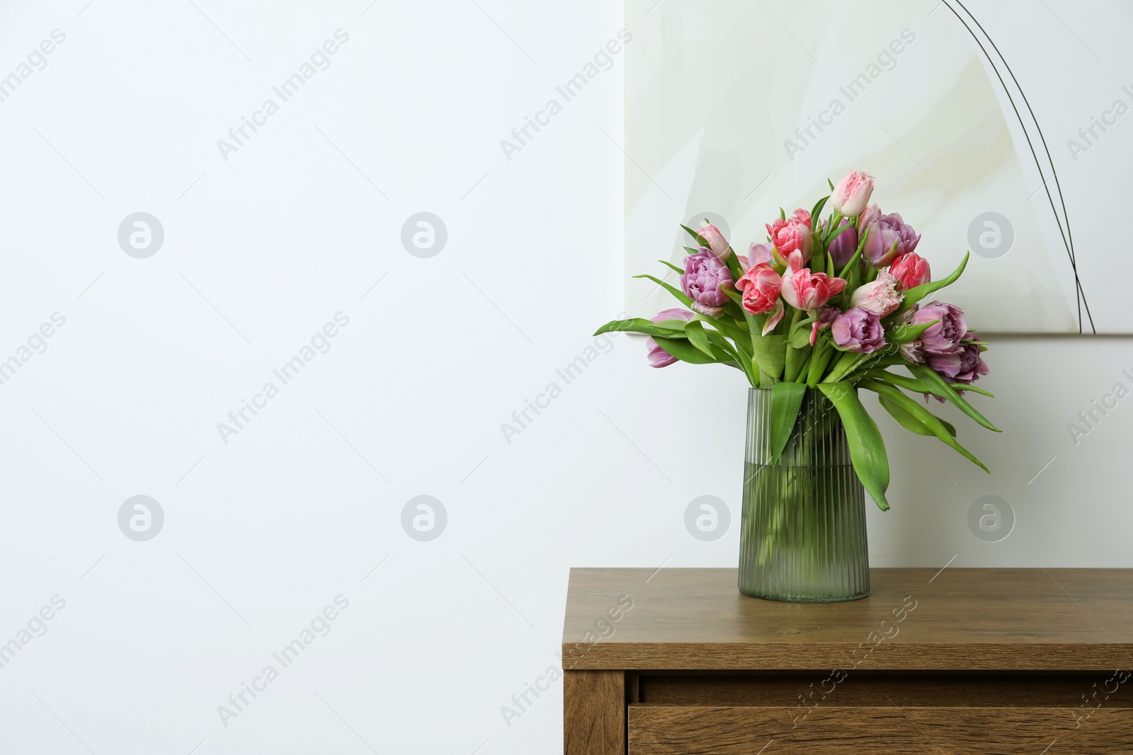 Photo of Beautiful bouquet of colorful tulip flowers on wooden table indoors. Space for text