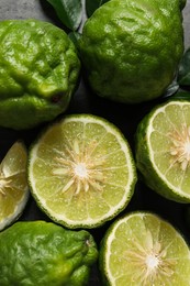 Photo of Fresh ripe bergamot fruits with green leaves on table, flat lay