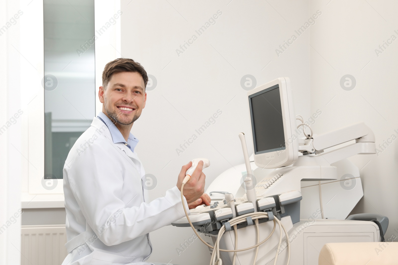 Photo of Sonographer operating modern ultrasound machine in clinic