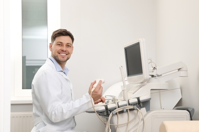 Sonographer operating modern ultrasound machine in clinic