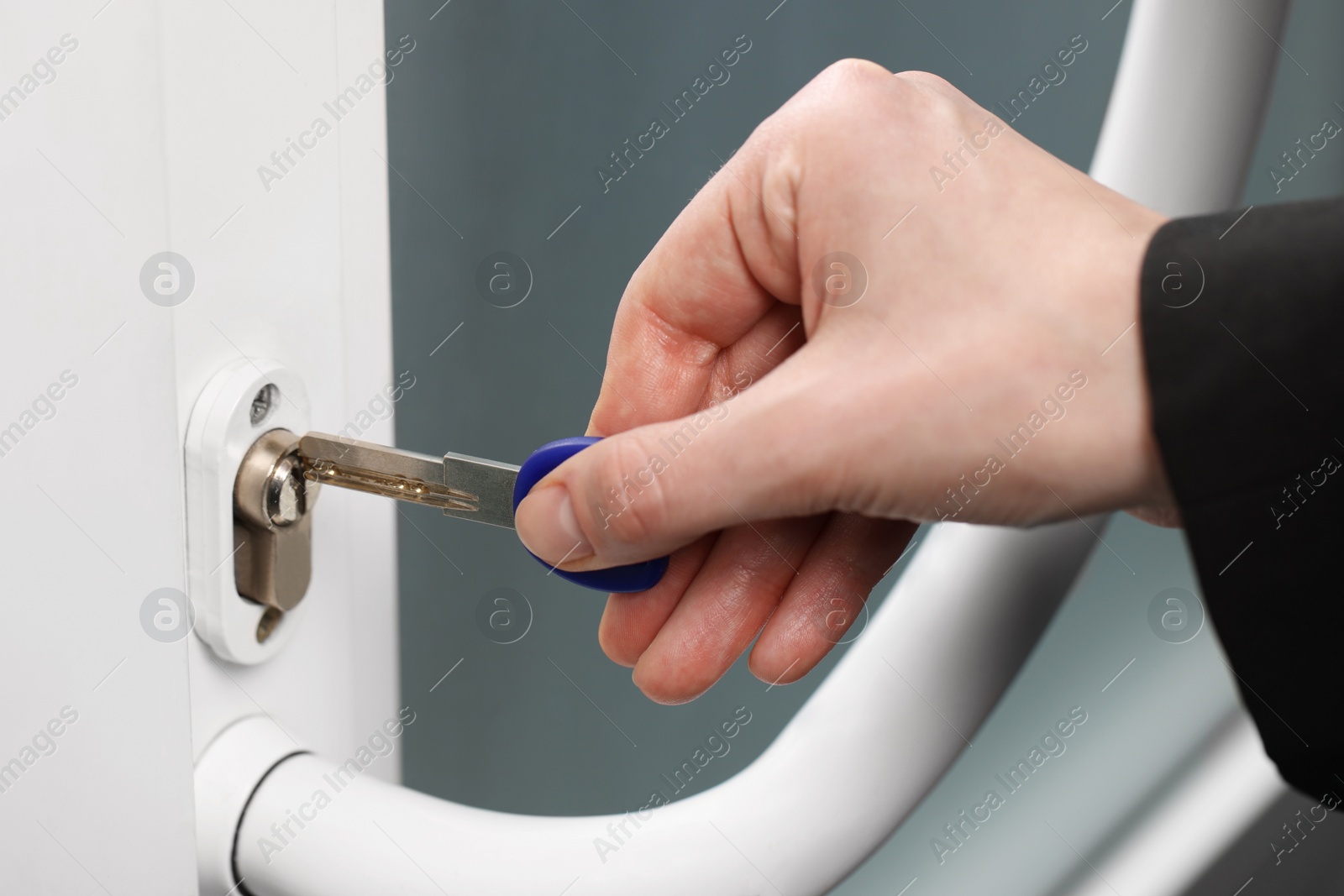 Photo of Woman unlocking door with key, closeup view