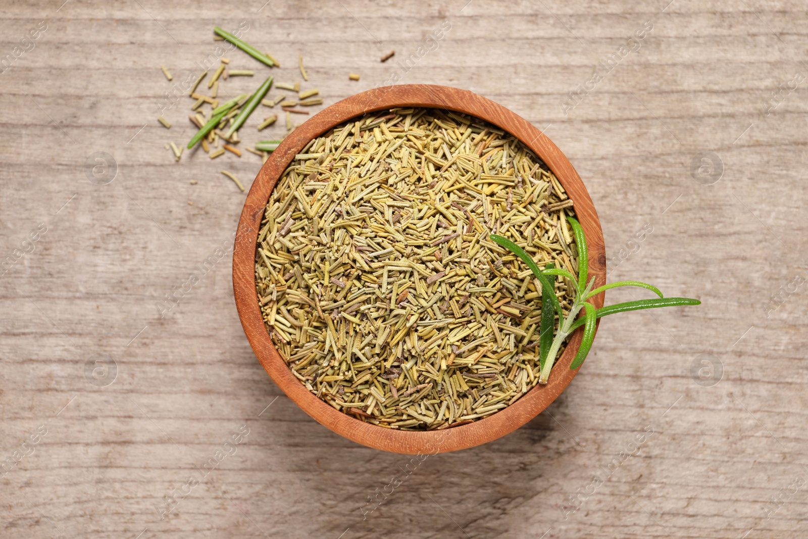 Photo of Dry and fresh rosemary in bowl on wooden table, top view