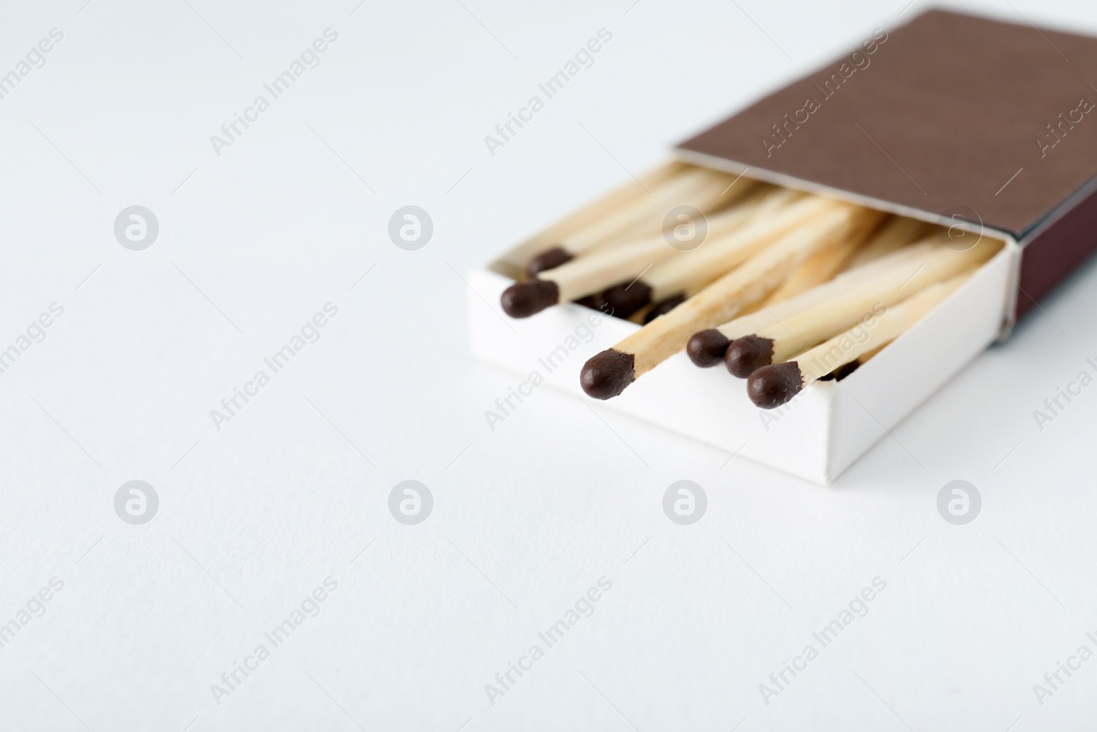 Photo of Cardboard box with matches on light background