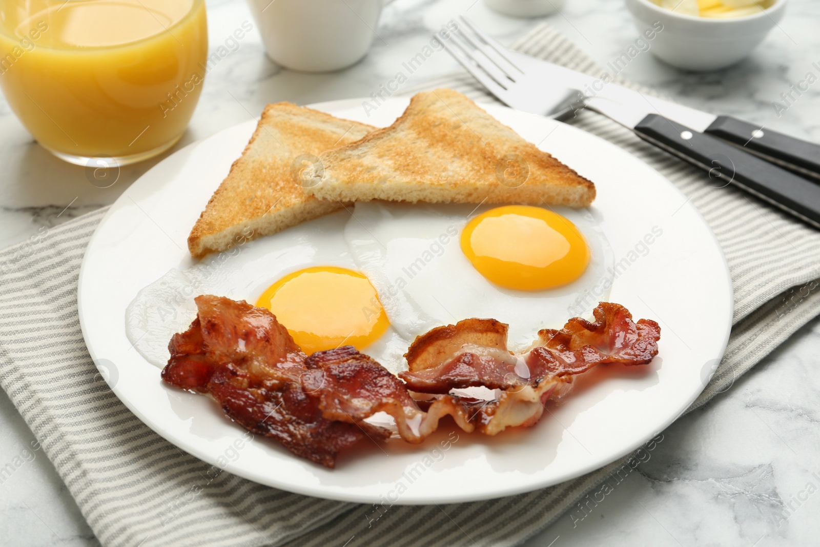 Photo of Delicious breakfast with sunny side up eggs served on white marble table, closeup