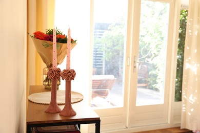 Photo of Bouquet of flowers and candles on wooden table indoors. Space for text