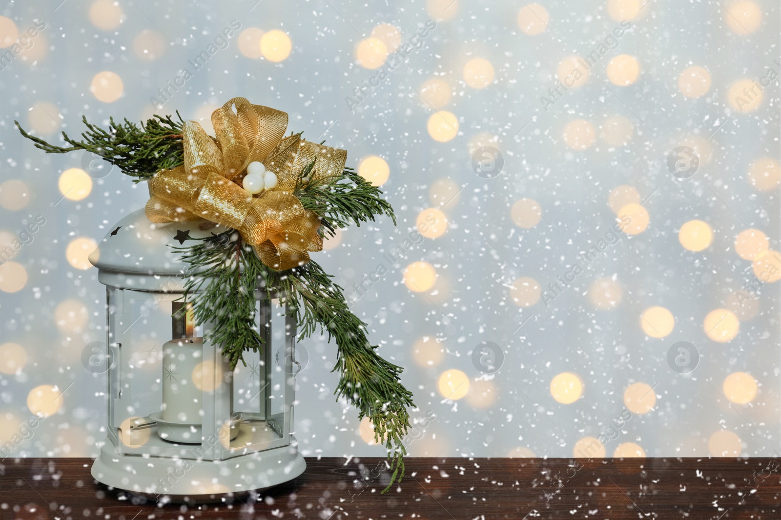 Image of Christmas lantern on wooden table, space for text. Bokeh effect