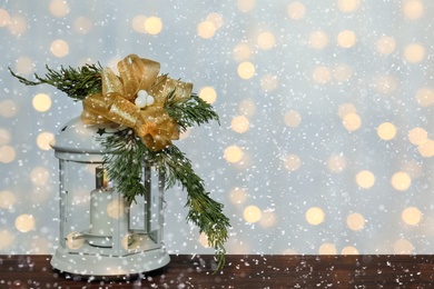 Christmas lantern on wooden table, space for text. Bokeh effect