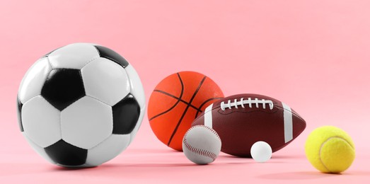 Photo of Many different sports balls on pink background. Banner design