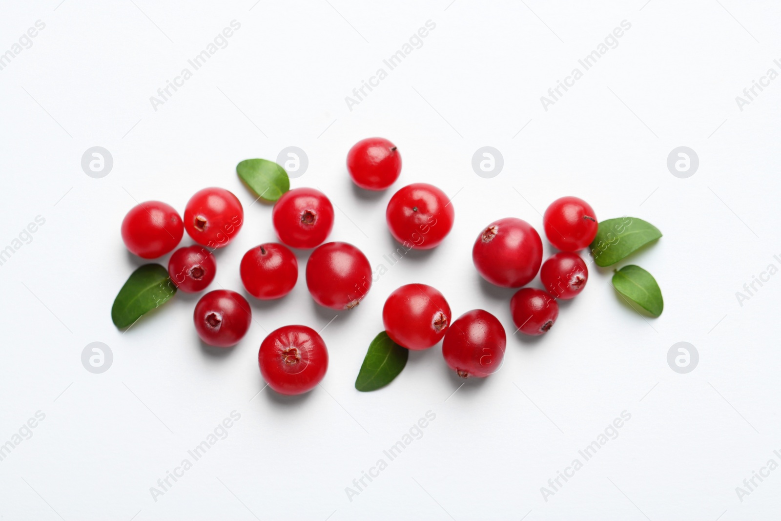 Photo of Fresh ripe cranberries and green leaves on white background, flat lay