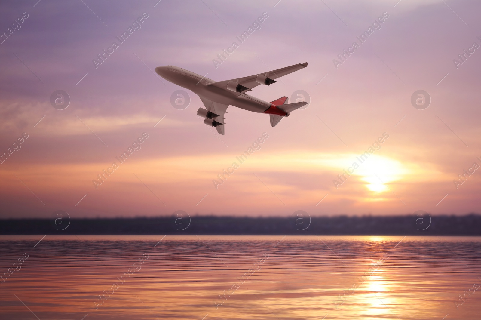 Image of Modern airplane flying over river during sunset