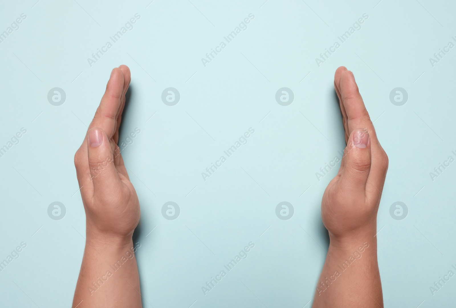 Photo of Woman holding on turquoise background, closeup of hands. Space for text