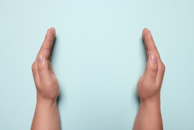 Photo of Woman holding on turquoise background, closeup of hands. Space for text