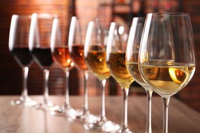 Photo of Different tasty wines in glasses on table