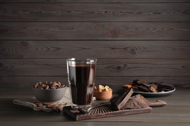 Glass of delicious hot chocolate on wooden table