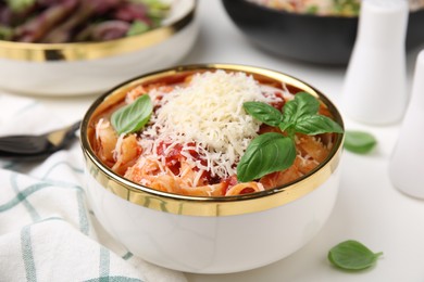 Photo of Delicious pasta with tomato sauce, basil and parmesan cheese on white table