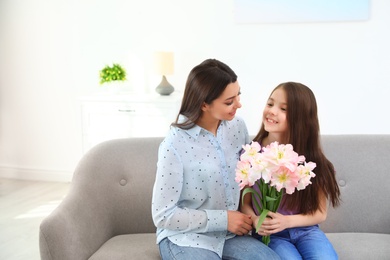 Photo of Little daughter congratulating her mom at home, space for text. Happy Mother's Day