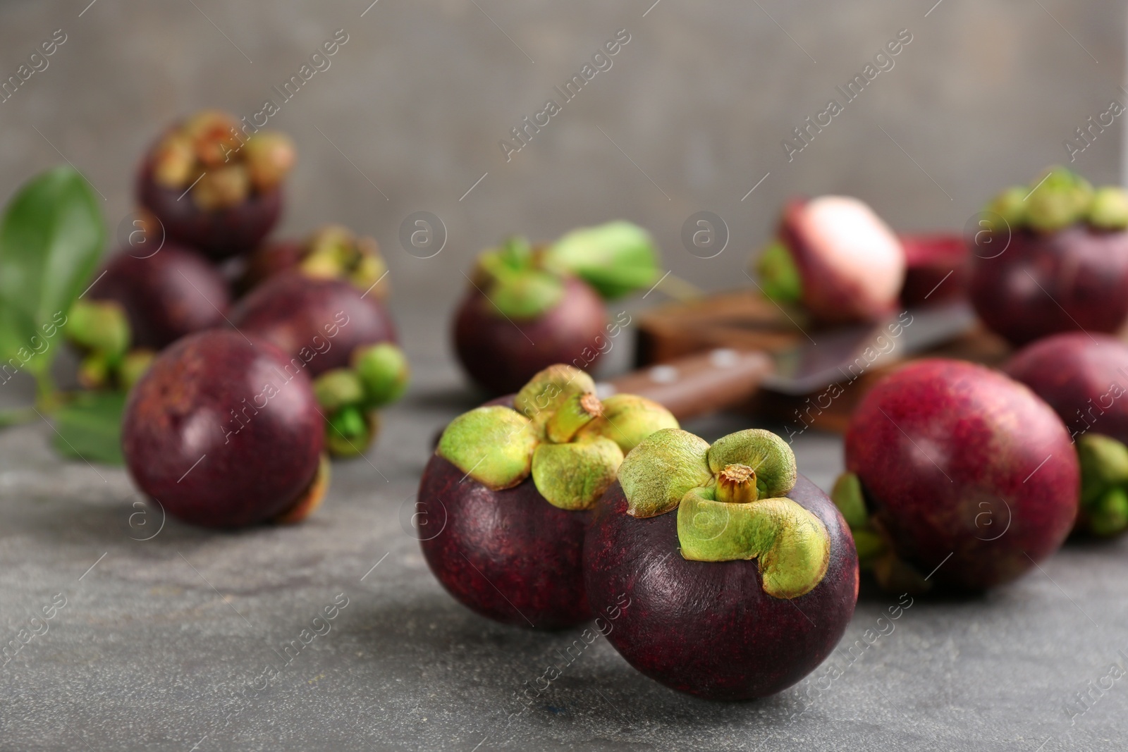 Photo of Fresh ripe mangosteen fruits on grey table